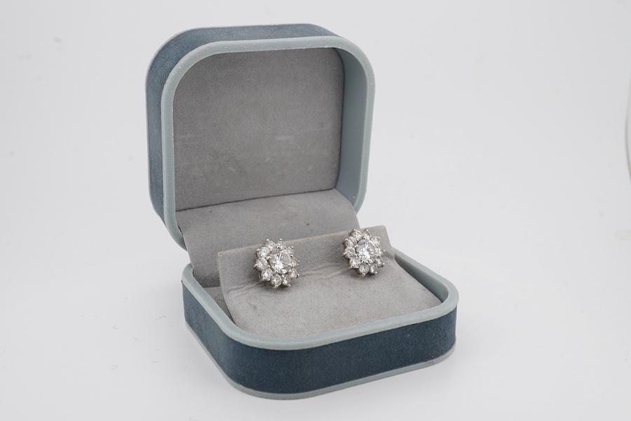 A pair of white metal (stamped 750) and diamond cluster set flower head ear studs, the central stone diameter approximately 6.5mm, overall diameter 9mm, gross weight 2.8 grams, no butterflies. Condition - fair to good